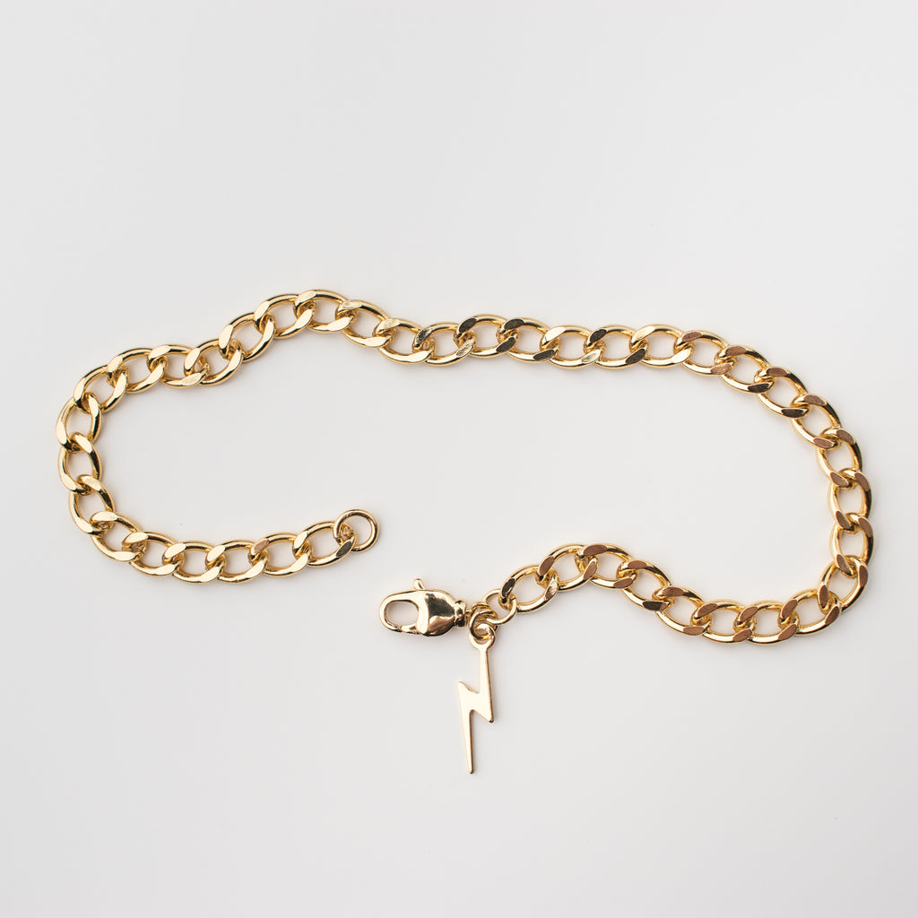 Thick gold anklet with a lightening bolt charm