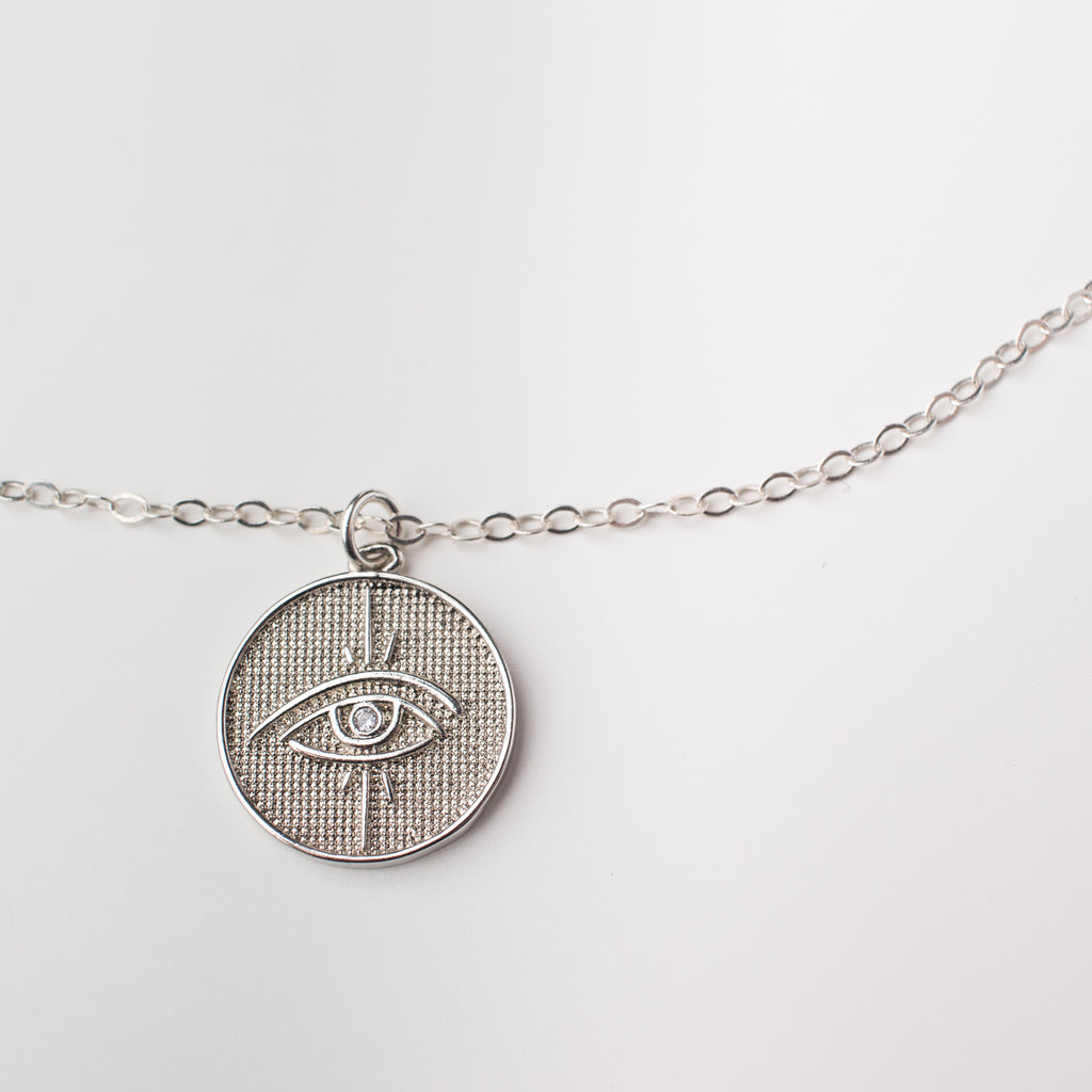 Sterling silver choker length chain with silver plated round eye pendant. 