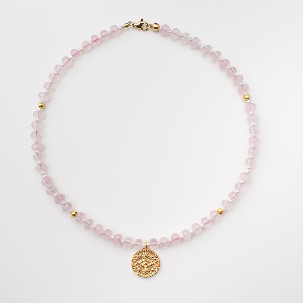 Pink gemstone necklace with rose quartz disk stones, mini freshwater pearls and gold embellishments. Pendant is a gold filled evil eye that is tarnish resistant. 