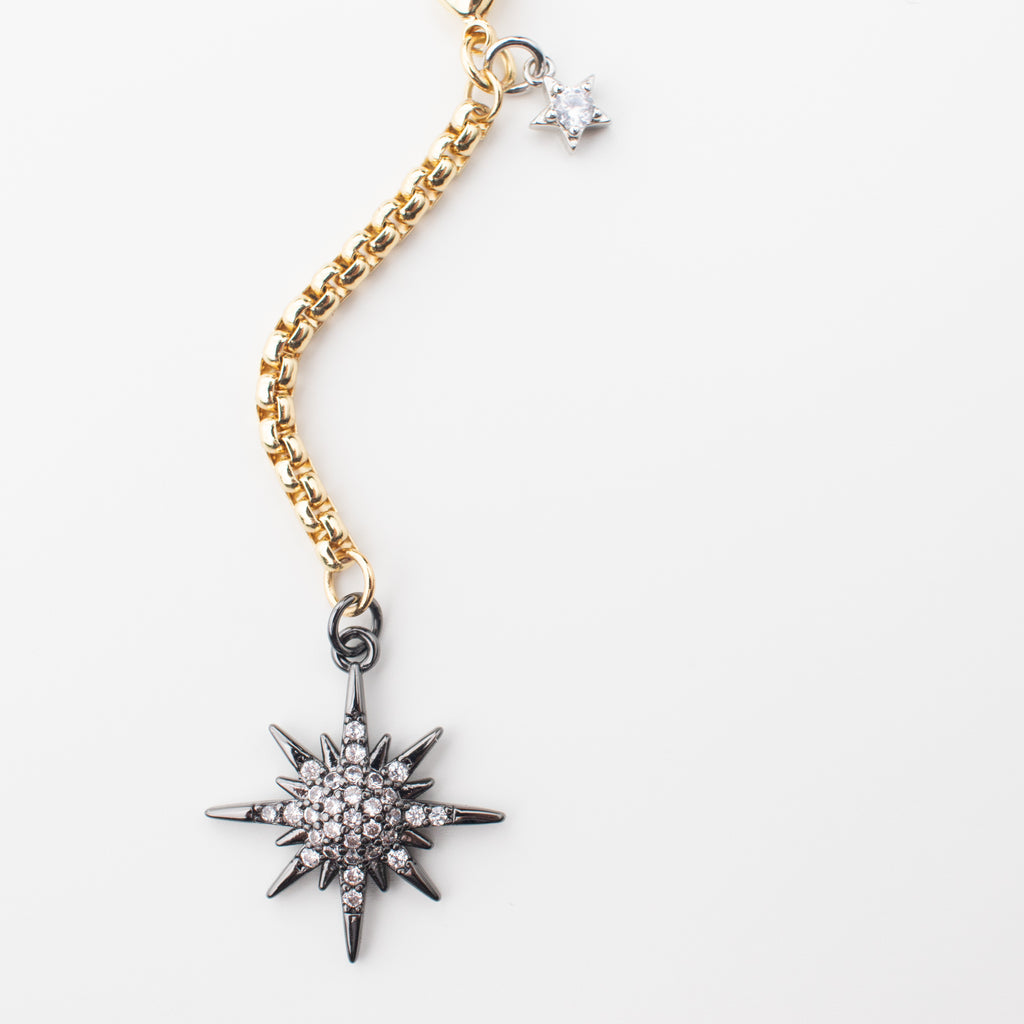 Gold chain necklace with a gunmetal moon and northern star that can be moved to different places to create a variety of looks. Chocker or medium length, with or without a crescent moon. studded in sparkle. This photo is of the northern star in a choker length. 