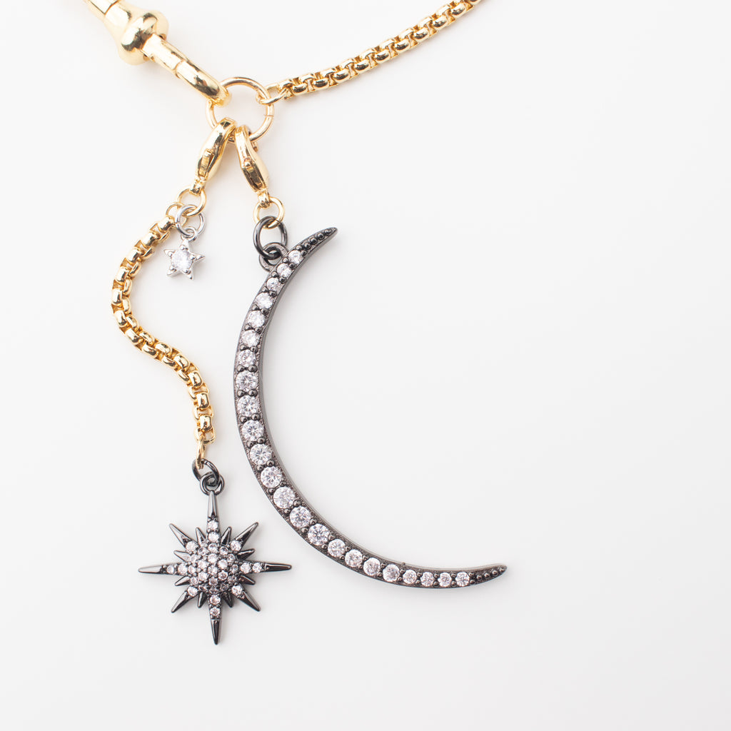 Gold chain necklace with a gunmetal moon and northern star that can be moved to different places to create a variety of looks. Chocker or medium length, with or without a crescent moon. studded in sparkle. 