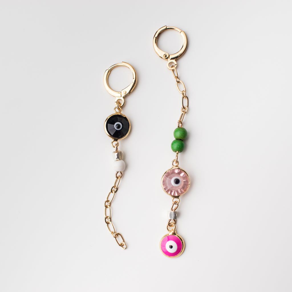 Gold mini hoop earrings with light pink, black & hot pink crystal eye charms. Magnesite beads in white and vibrant green, mismatched style earring.