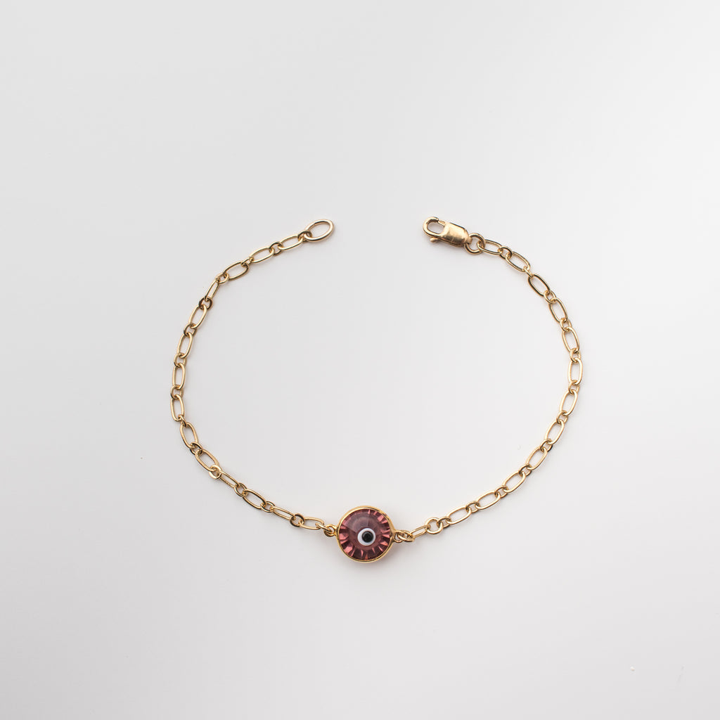 Gold bracelet with rose coloured crystal eye charm.