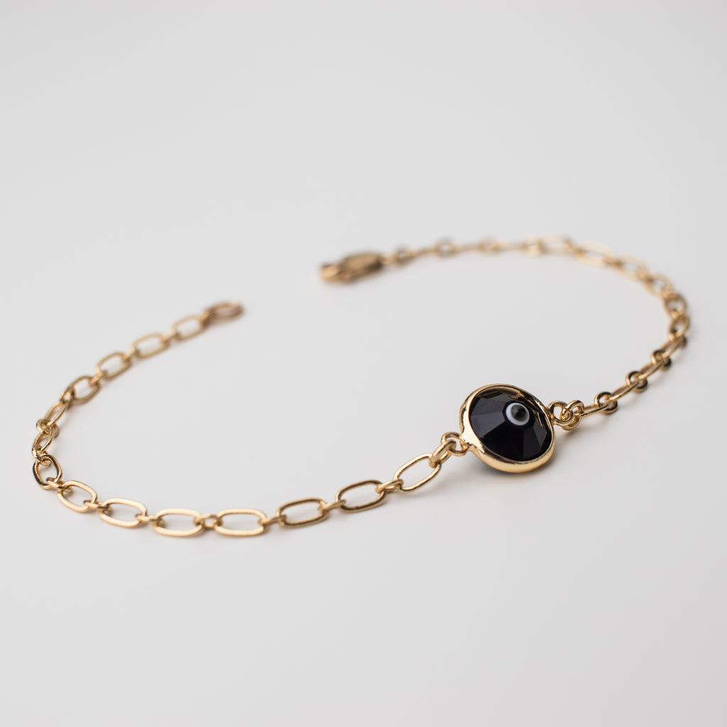 Gold bracelet with black eye crystal charm.
