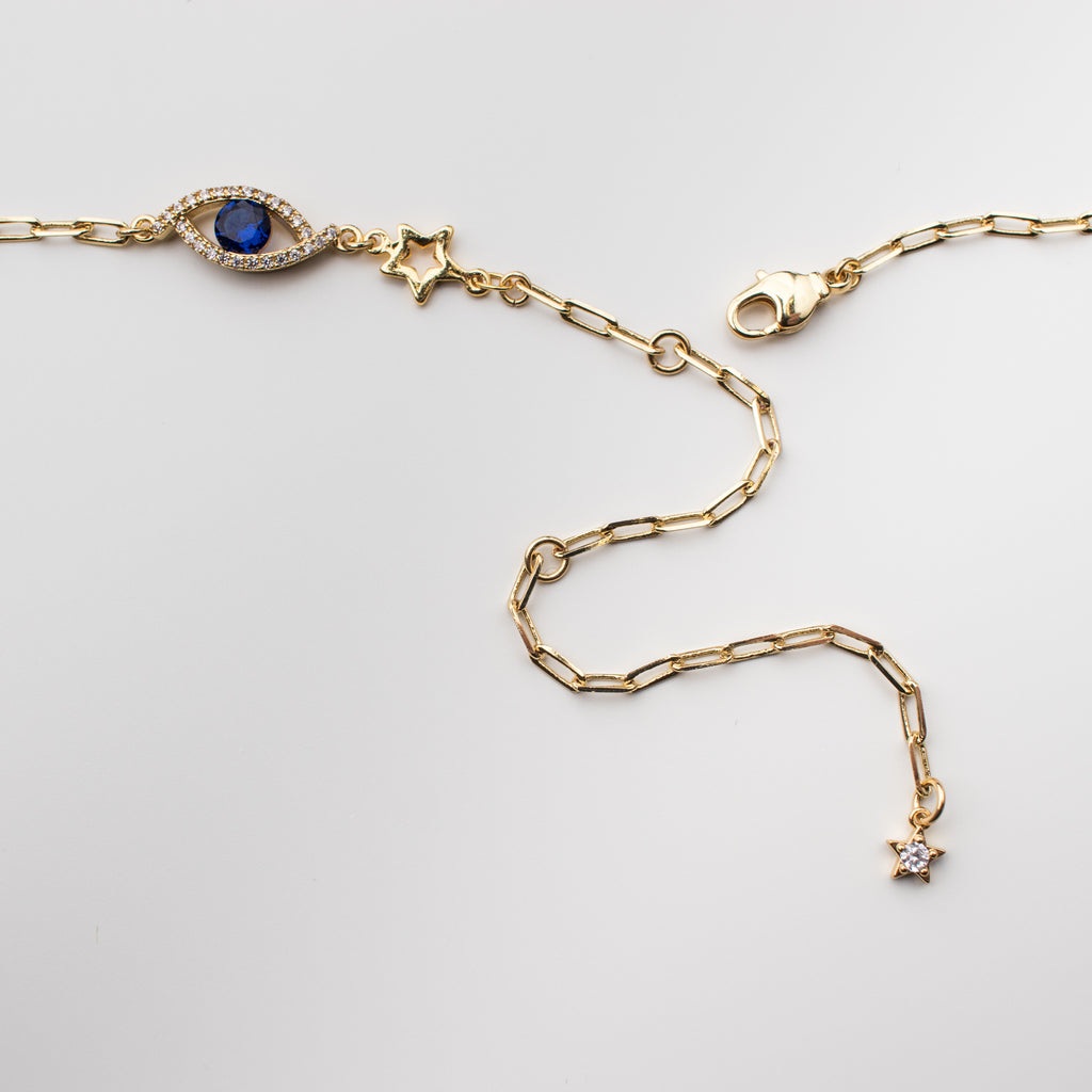 Gold belly chain with cobalt blue zirconium eye charm and gold stars.