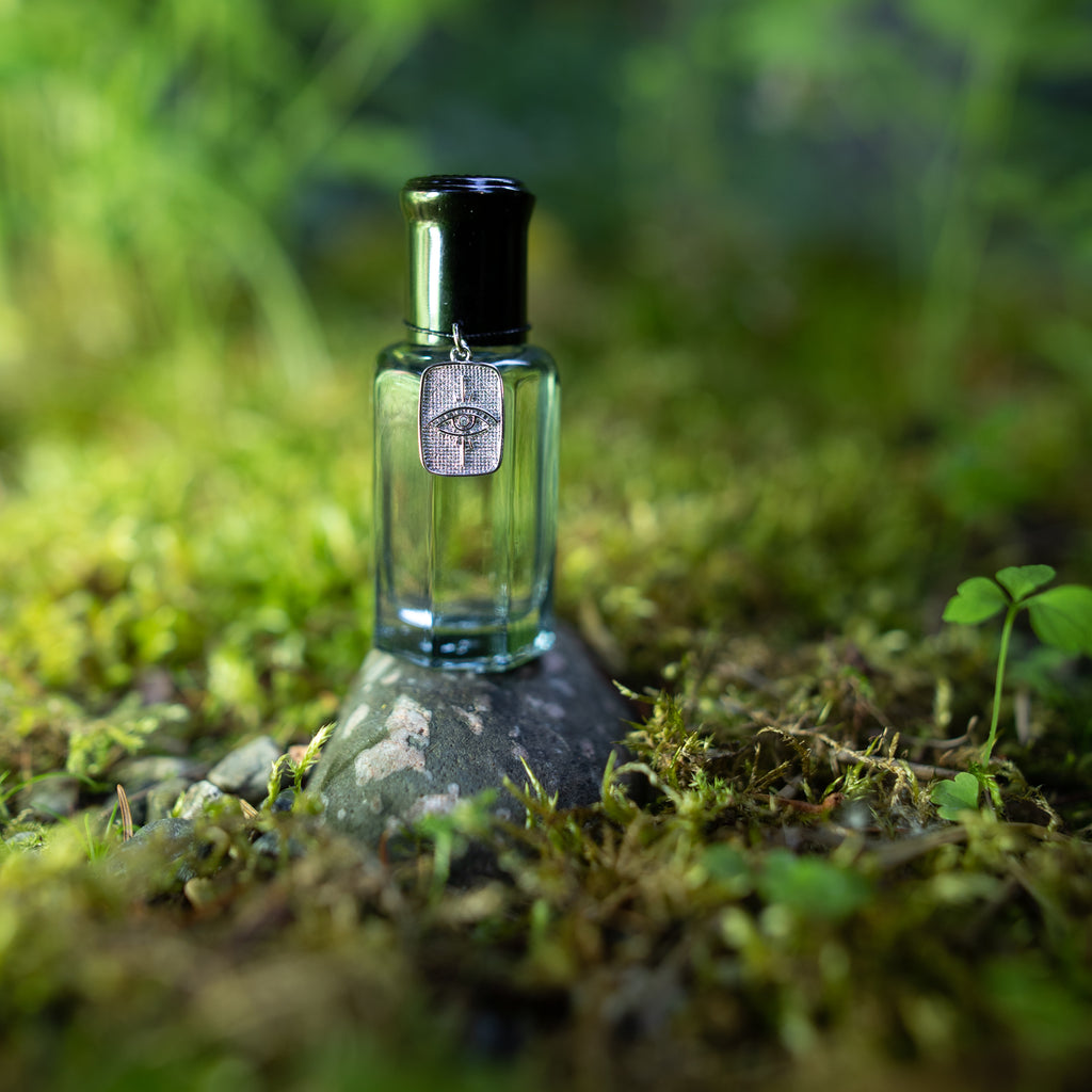 Talismanic 01. Bourbon, vanilla, tobacco, sandalwood and clover cologne, fragrance for men, unisex scent, natural fragrance with a silver eye charm for inner wisdom. Glass bottle with a roller ball dispenser.