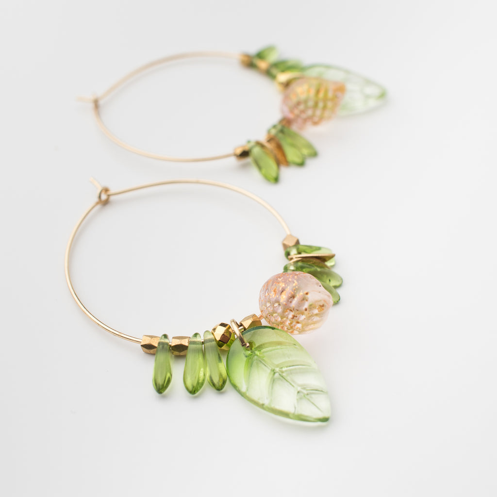 Clear green glass leaf and shards with a blush lemon drop on gold plated hoops, matching earrings style.