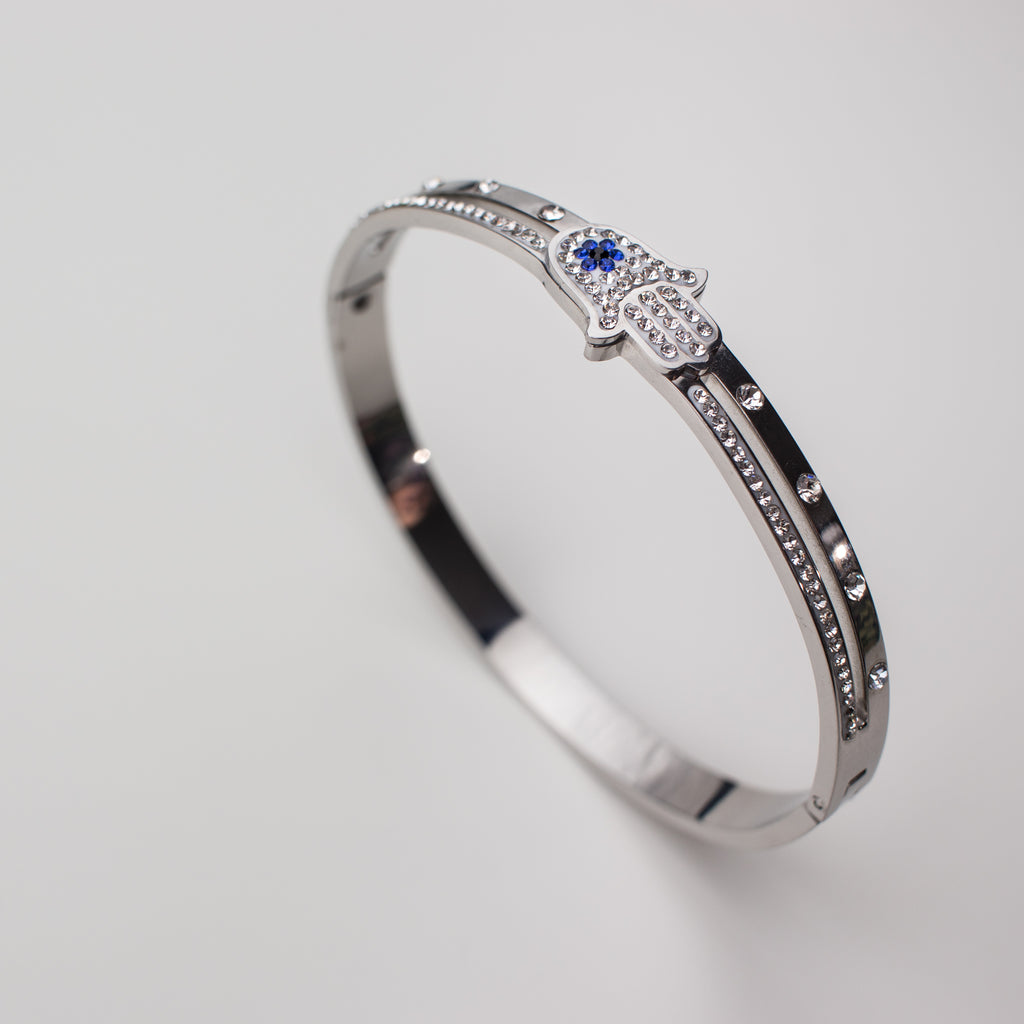 Stainless steel bracelet with hamsa hand and cubic zirconia, bangle style.
