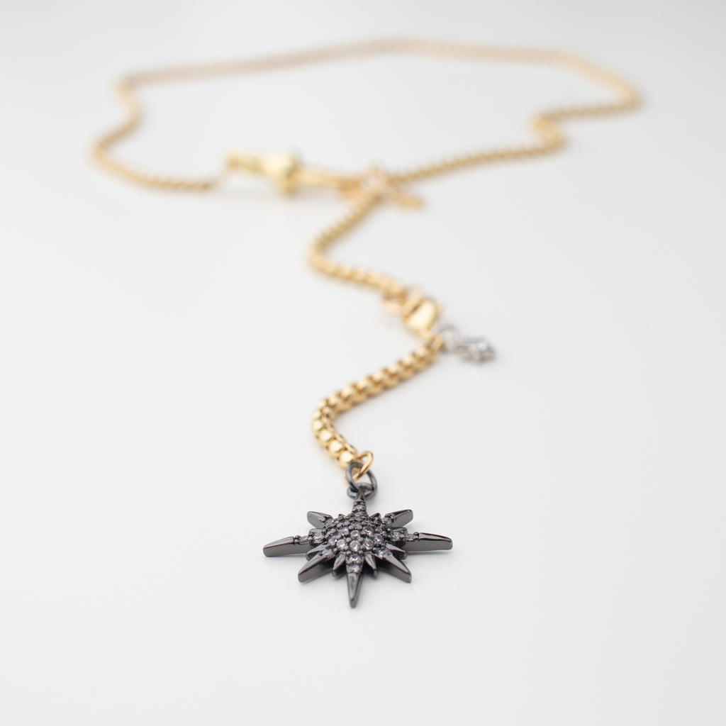 Gold chain necklace with a gunmetal moon and northern star that can be moved to different places to create a variety of looks. Chocker or medium length, with or without a crescent moon. studded in sparkle. This photo is of the northern star in a choker length. 