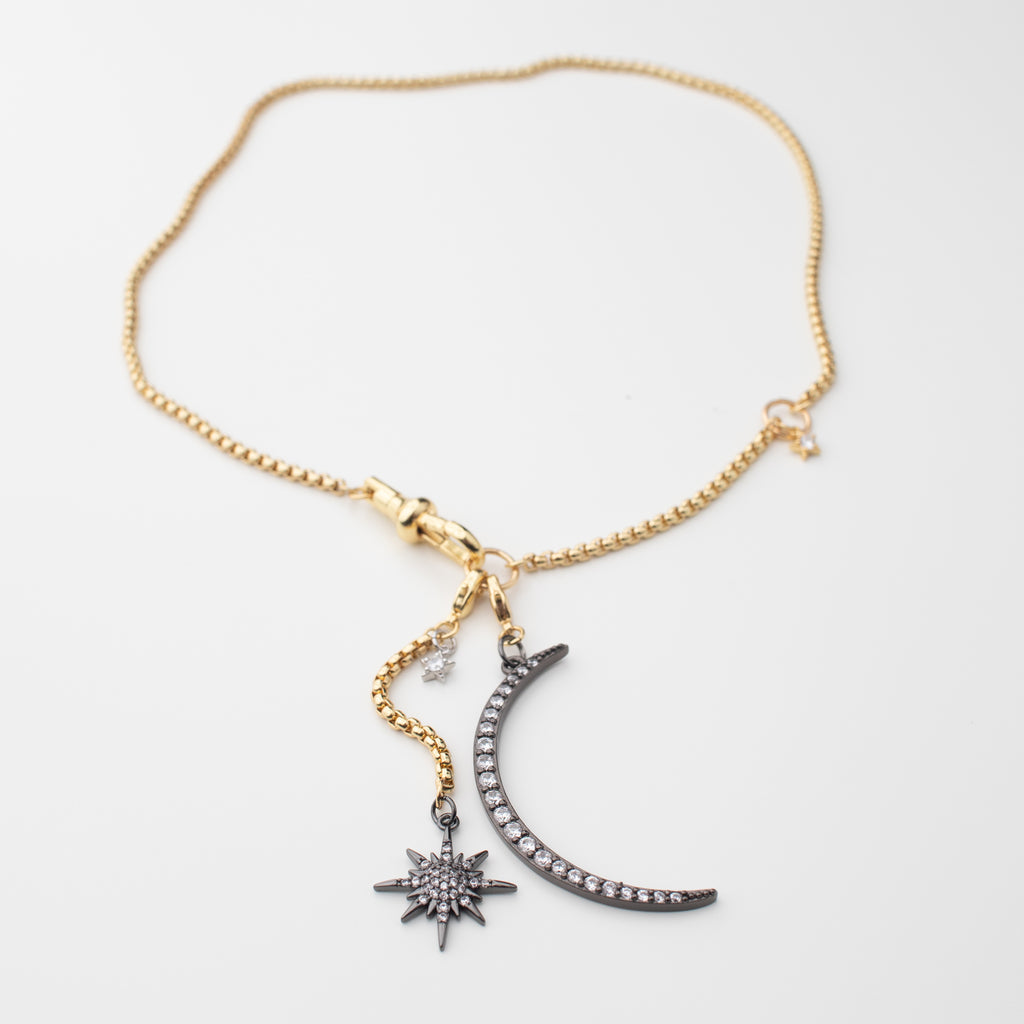 Gold chain necklace with a gunmetal moon and northern star that can be moved to different places to create a variety of looks. Chocker or medium length, with or without a crescent moon. studded in sparkle. 