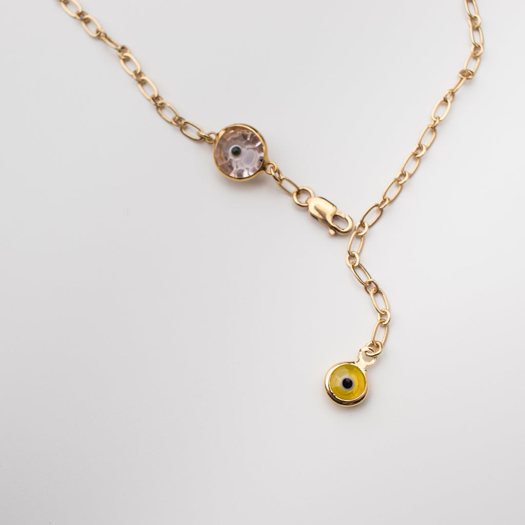 Gold anklet with a light pink crystal eye and yellow eye charms.