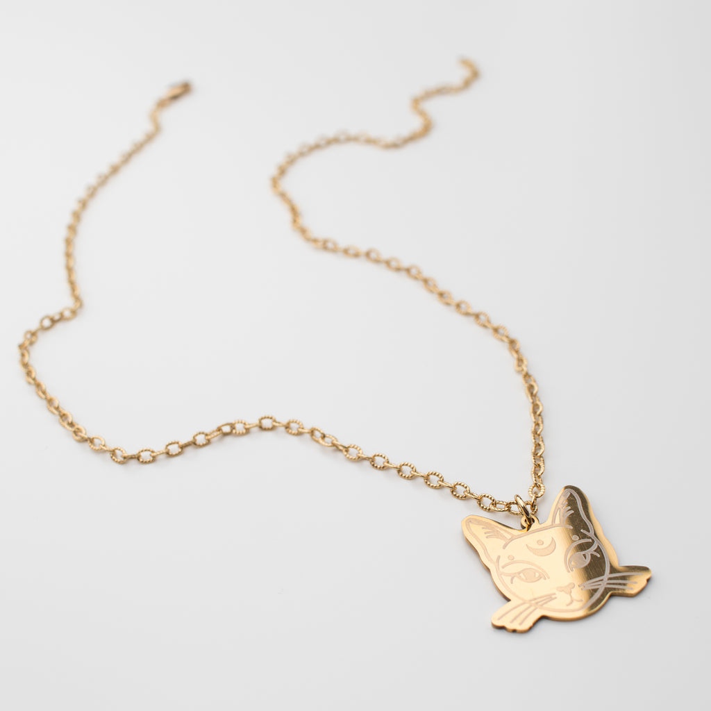 Shinny gold cat pendant on a gold chain necklace. 