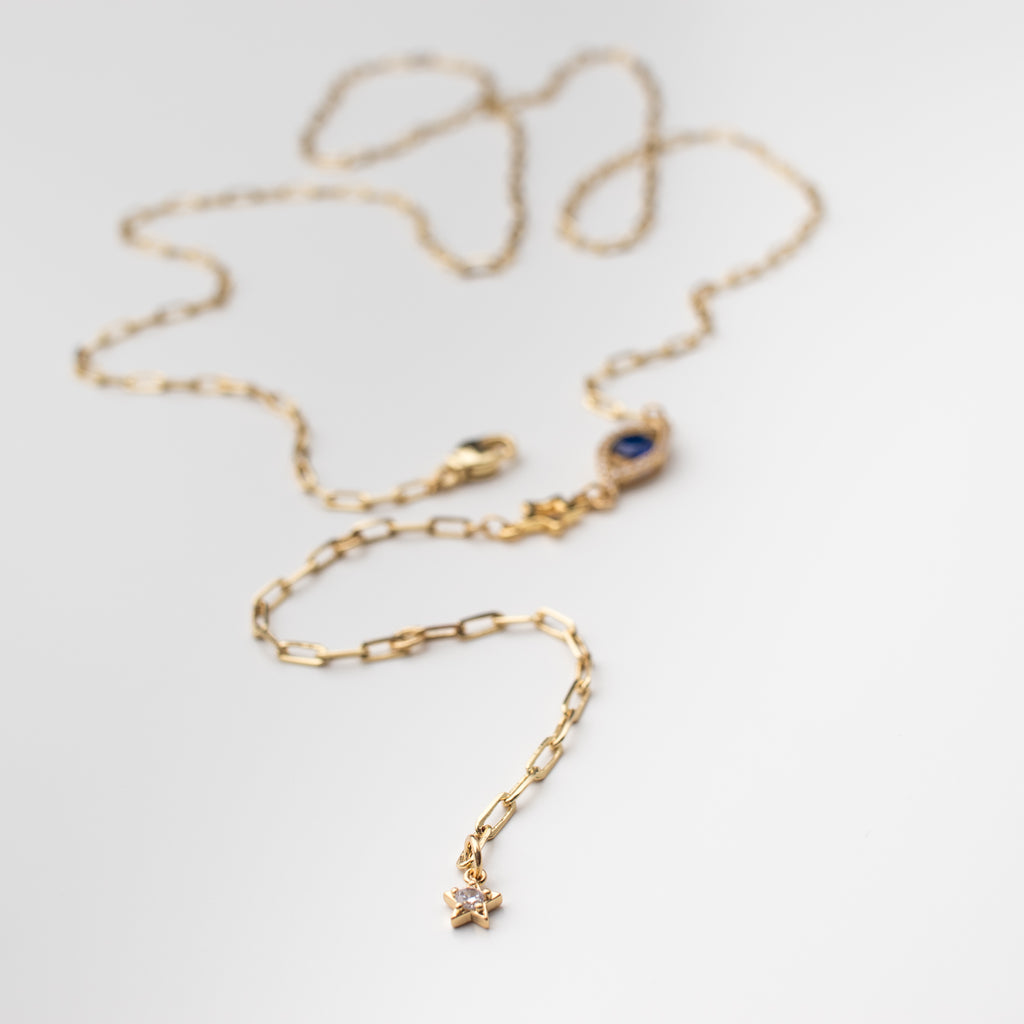 Gold belly chain with cobalt blue zirconium eye charm and gold stars.