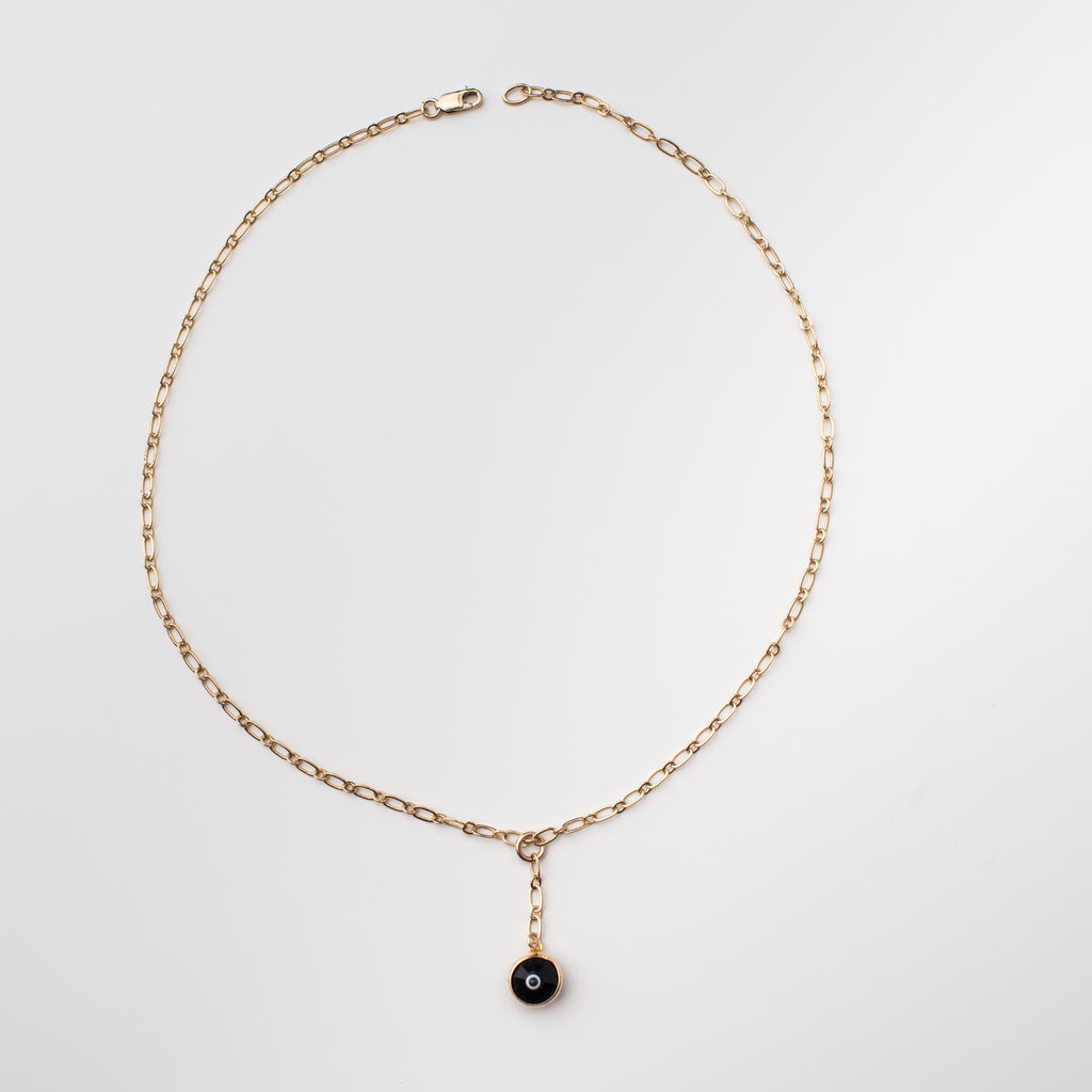 Gold necklace with black coloured crystal eye charm.