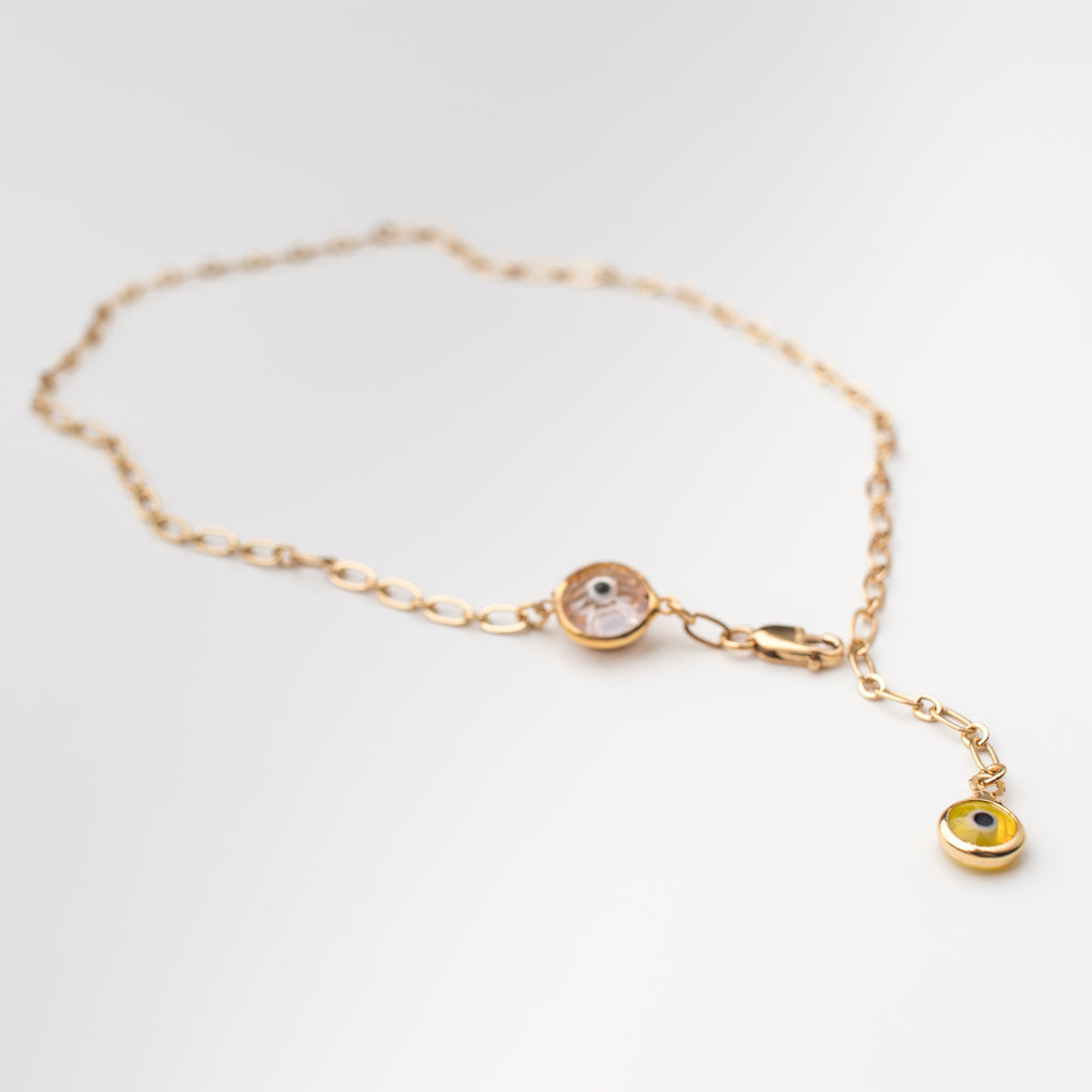 Gold anklet with a light pink crystal eye and yellow eye charms.